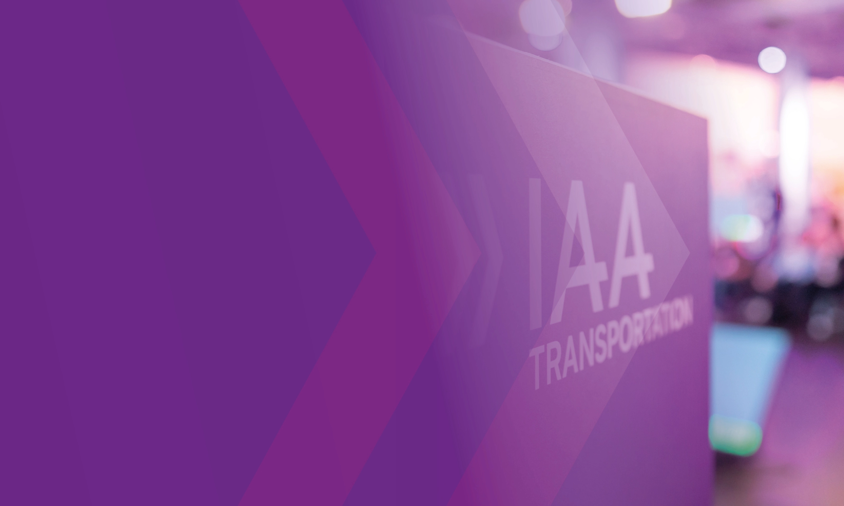 Sign with the text "IAA TRANSPORTATION" at a trade fair, purple design in the foreground.