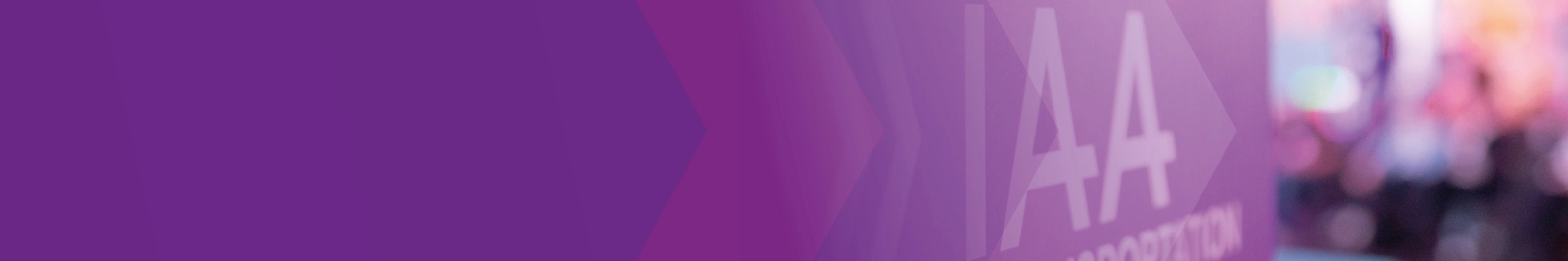 Sign with the text "IAA TRANSPORTATION" at a trade fair, purple design in the foreground.
