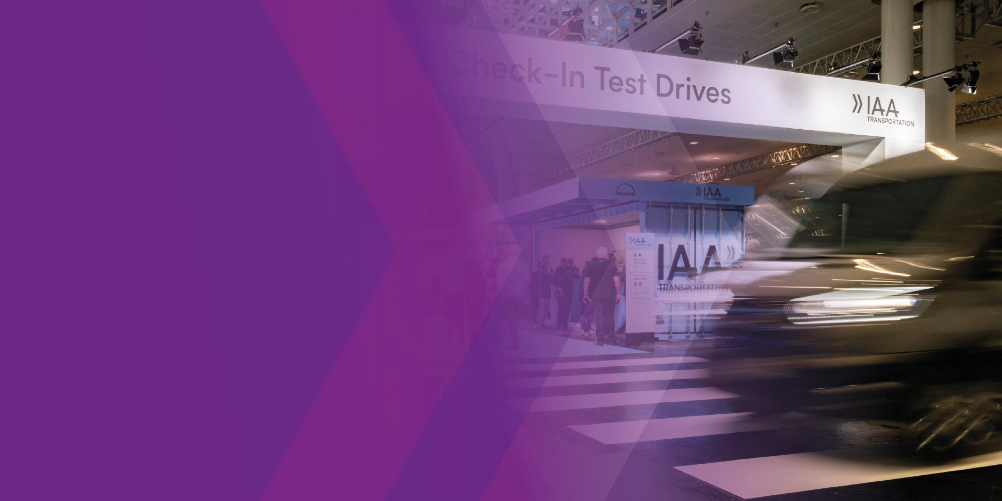 A blurred vehicle passes the IAA Transportation test drive check-in area, partly overlaid with purple graphics.