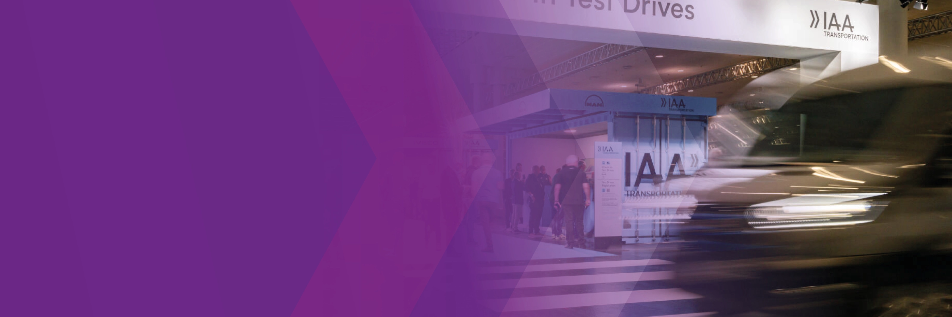 A blurred vehicle passes the IAA Transportation test drive check-in area, partly overlaid with purple graphics.