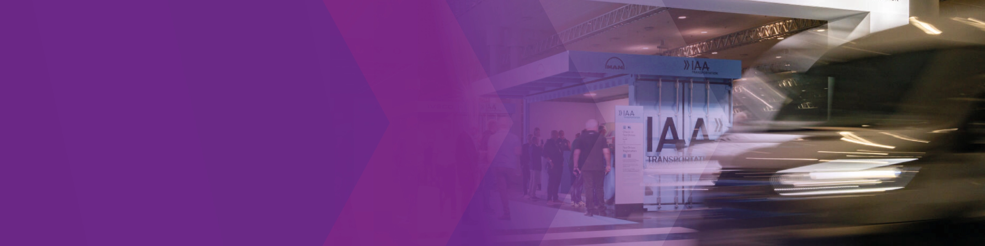 A blurred vehicle passes the IAA Transportation test drive check-in area, partly overlaid with purple graphics.