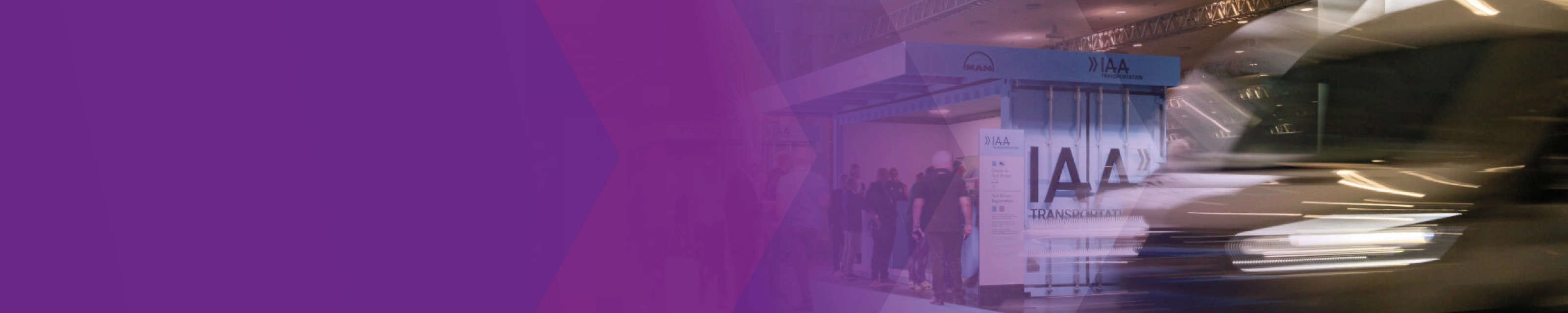 A blurred vehicle passes the IAA Transportation test drive check-in area, partly overlaid with purple graphics.